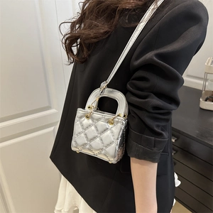 Silver metallic quilted mini crossbody bag with top handle shown on model in summer style