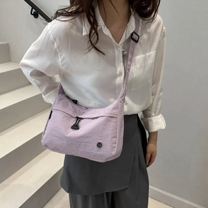 Lavender large capacity nylon crossbody bag worn by model with adjustable strap