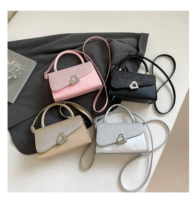 Detail of square bags with sequined flaps and heart-shaped metal locks in four colors