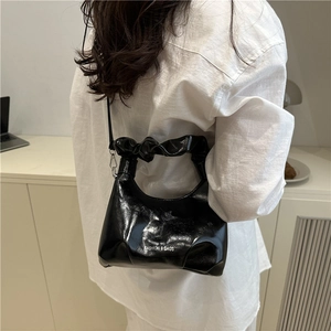 Black glossy bucket bag with trendy ruched handle and detachable crossbody strap