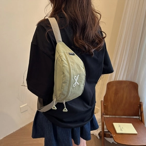 Minimalistische hellgrüne Bauchtasche mit grauem Gurt, getragen von Model in Freizeitlook