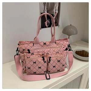 Pink corduroy tote bag detail with black bow print and functional front zipper pockets
