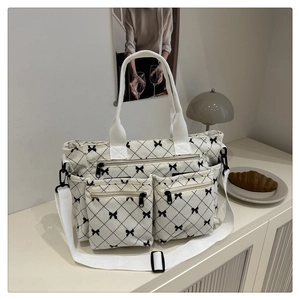 Detail view of corduroy tote bag with black bow print and multiple functional storage pockets