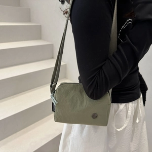 Petit sac bandoulière en nylon vert avec sangle réglable et logo M pour un style décontracté