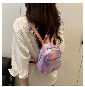 Close-up of mini gradient backpack with heart patterns and gold floral zipper detail