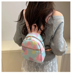 Detailed back view of a mini colorful floral backpack with heart patterns and gold hardware