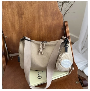 Detail of khaki nylon tote bag featuring a detachable coin purse on a wide shoulder strap