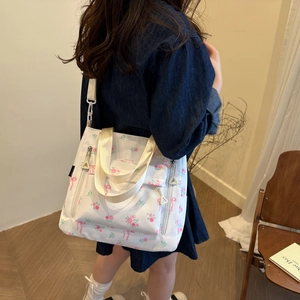 Floral canvas tote bag with pink rose patterns and bow details on a female model