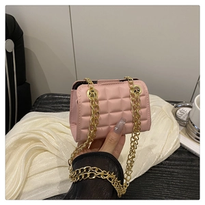 Close-up of pink quilted mini chain bag with gold strap and luxury lattice stitching