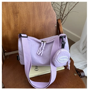 Lavender purple nylon tote bag with a small round pouch and wide adjustable strap