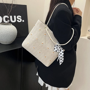 Borsa tote in paglia con ricamo a margherite e foulard a pois indossata dal modello