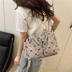 Grey quilted nylon tote bag with black bow accents and multiple functional pockets