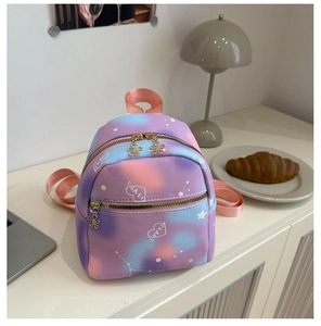 Close-up of mini gradient backpack featuring heart patterns and golden flower charm