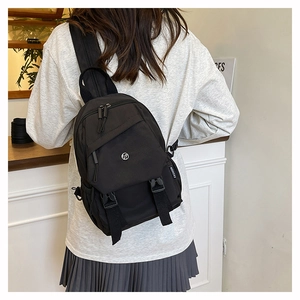 Close-up of minimalist black drawstring travel backpack with adjustable strap on model