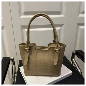 Detail of lychee pattern leather tote with golden D-ring hardware and neat stitching