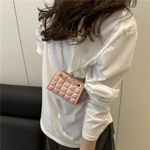 Pink quilted crossbody bag with gold chain strap shown on model with white shirt