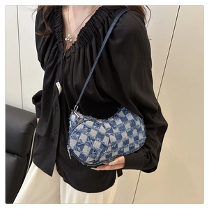Detail of blue and white checkered denim crescent bag with frayed edges and small pouch