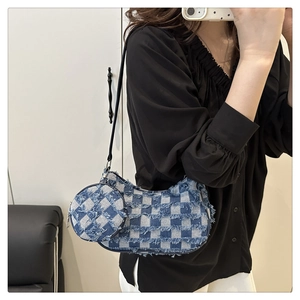 Close-up of checkered denim underarm bag with fringe details and small round coin purse