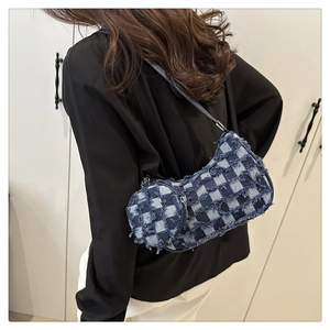 Rear view of a blue and white checkered denim crescent bag with fringe and round pouch