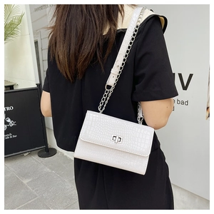 Detailed view of white crocodile pattern square bag with silver metal swivel clasp