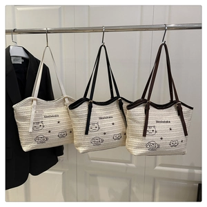Close-up of woven tote bags with cat patterns and leather straps in multiple colors