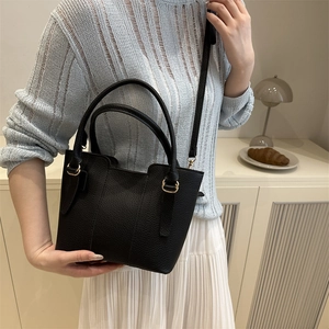 Sac seau noir pour femme avec doubles poignées et anneaux dorés en scène de vie