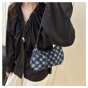 Detail of denim plaid crescent bag featuring distressed fringe and mini round coin purse