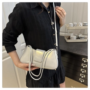 Detail view of silver pearlescent patent leather underarm bag with sleek buckle and strap