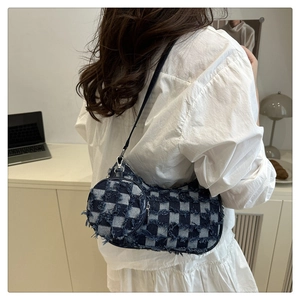 Close-up of crescent denim crossbody bag with fringe edges and small round coin purse