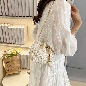 Elegant cream woven bucket bag with gold chain strap and pearl drawstring detail