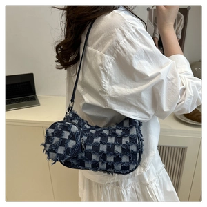 Detail view of denim checkered crossbody bag with frayed edges and round coin purse