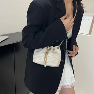 Minimalist white woven bucket bag with gold chain strap and pearl drawstring details
