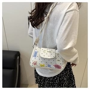 Vista posteriore di una modella con borsa sottobraccio a pois in un contesto casual