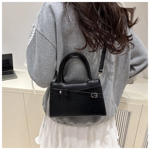 Black vintage leather square bag with bow detail shown on model for size reference