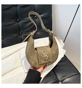 Detail of vintage olive green crescent bag with matte texture and metallic logo