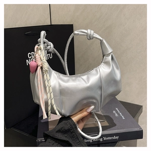 Detailed close-up of a metallic silver hobo bag with ruched design and knot handle details