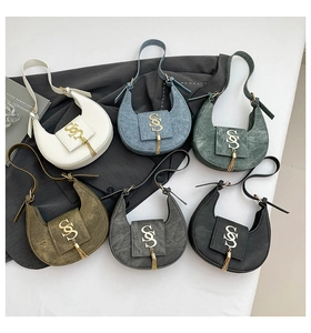Group display of crescent underarm bags in six colors with gold metal letter S detail
