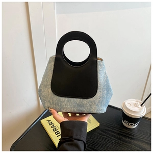 Detail of light blue denim tote bag with sparkling rhinestones and black leather handle