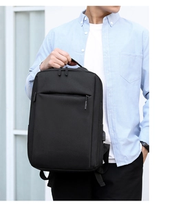 Close-up of sleek black commute backpack with reinforced top handle and front zipper pocket