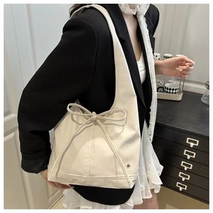 Detailansicht der cremefarbenen Hobo-Bag mit großer Schleife und weicher Kunstledertextur
