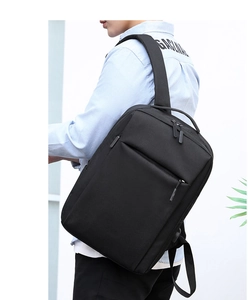 Detail of black waterproof backpack showing USB charging port and sleek business design