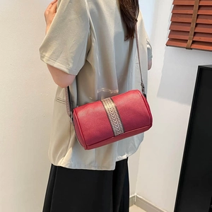 Red lychee texture pillow bag with geometric ethnic strap worn by model