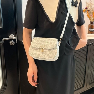 Women's straw woven saddle bag with floral embroidery and gold buckle detail