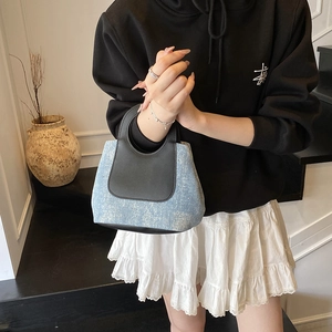 Fashionable denim bucket bag with rhinestone accents and black leather trim handles