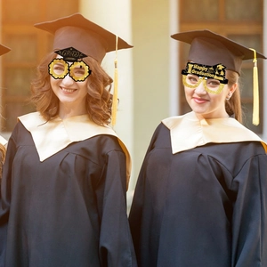 Dettaglio di occhiali di carta per diploma in nero e oro indossati per foto di festa