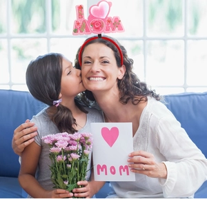 Close-up of mother and daughter wearing pink I LOVE MOM floral headband for Mother's Day