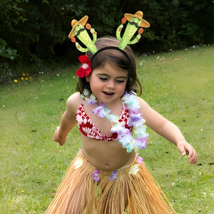 Fillette portant un ensemble de fête hawaïen avec serre-tête cactus et jupe d'herbe