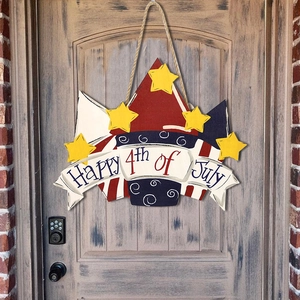Close-up of Happy 4th of July wooden door hanger with stars on a rustic door