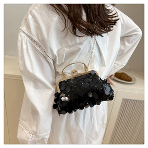 Détail du sac oreiller à paillettes noires avec anse dorée et bandoulière chaîne