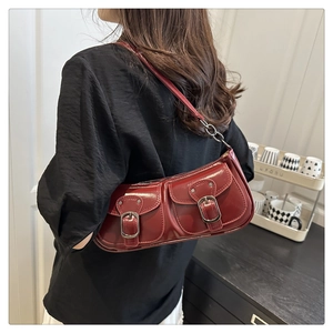 Détail du sac à bandoulière rétro bordeaux avec finition brillante et deux poches